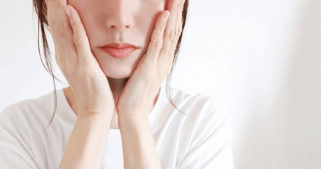 40代で親知らずの抜歯に不安を感じ、頬に手を当てて悩んでいる女性のイメージ