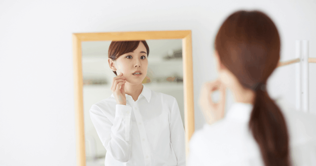 顔に変化があるか確認する女性